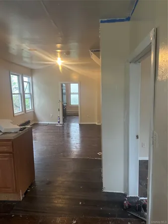 a view of a hallway with wooden floor and a living room