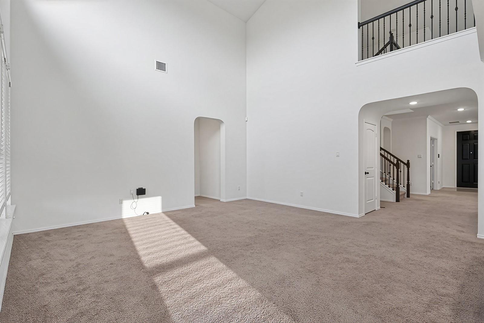 4600 Ercolano Lane Round Rock, TX 78665 - Photo 15 of 37 Spacious living area featuring high vaulted ceilings, light brown carpet flooring, and white wall finishes