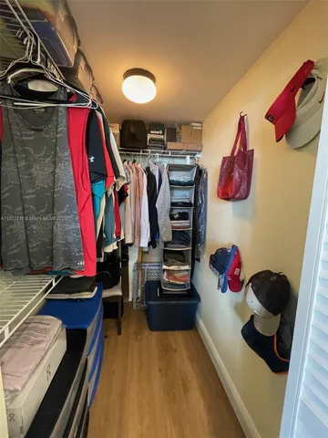 a view of walk in closet with clothes and shoes