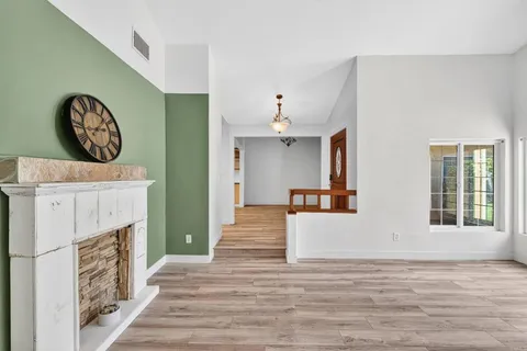 a view of a kitchen with wooden floor and a fireplace