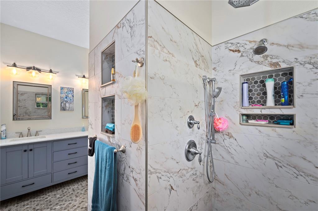 1212 Reynolds Road De Leon Springs, FL 32130 - Photo 20 of 32 a bathroom with a granite countertop shower a sink and a mirror