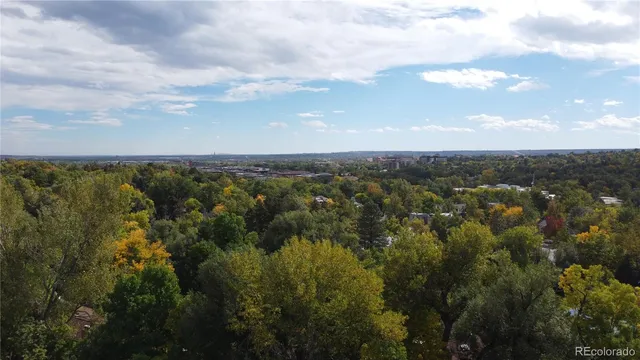 an aerial view of residential houses with outdoor space and trees