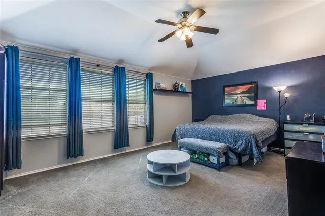 a spacious bedroom with a bed and a chandelier