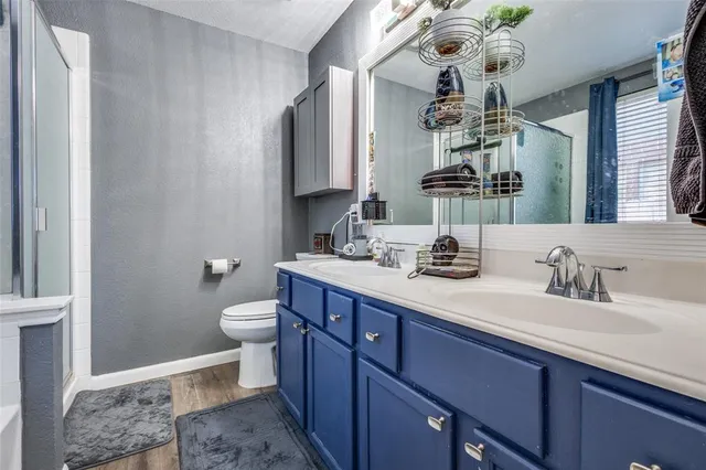 a bathroom with a double vanity sink mirror and toilet