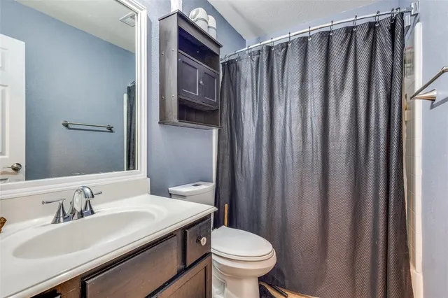 a bathroom with sink a mirror a toilet and vanity