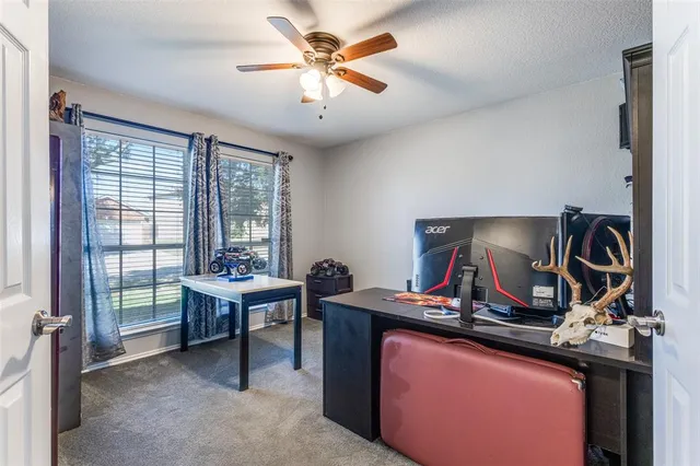 a view of a workspace with furniture and a window