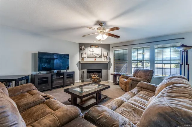 a living room with furniture a fireplace and a flat screen tv