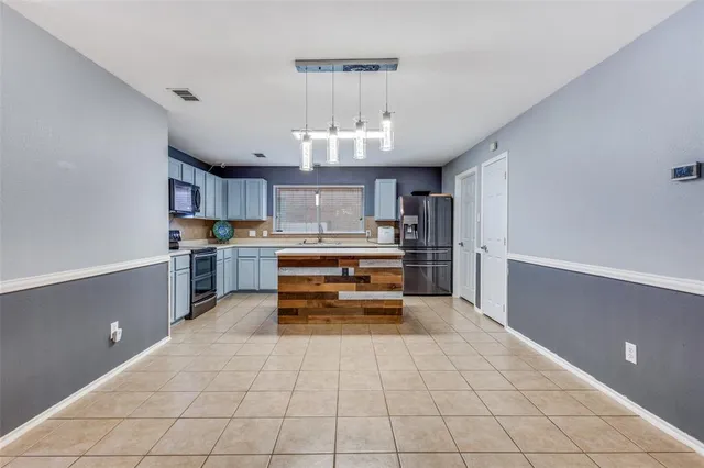 a kitchen with granite countertop a refrigerator and a stove top oven