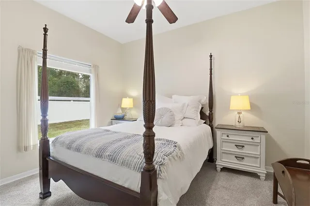a bedroom with a bed a chandelier and a window