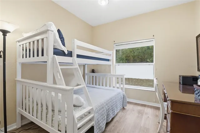 a view of a bedroom with wooden floor and windows