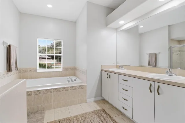 a bathroom with a tub a sink and a window