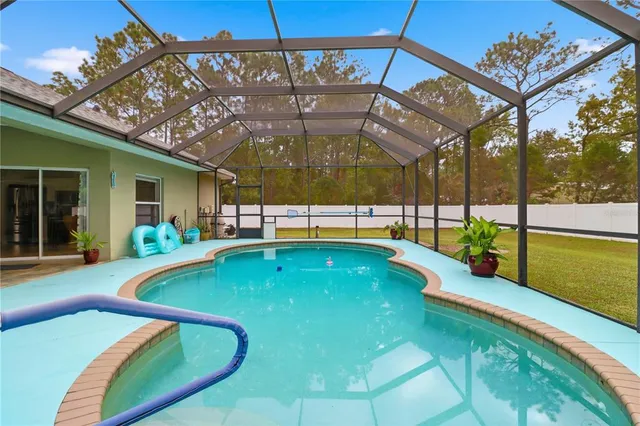 a view of a swimming pool with a patio and a yard
