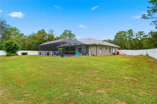 a view of house with garden space and swimming pool