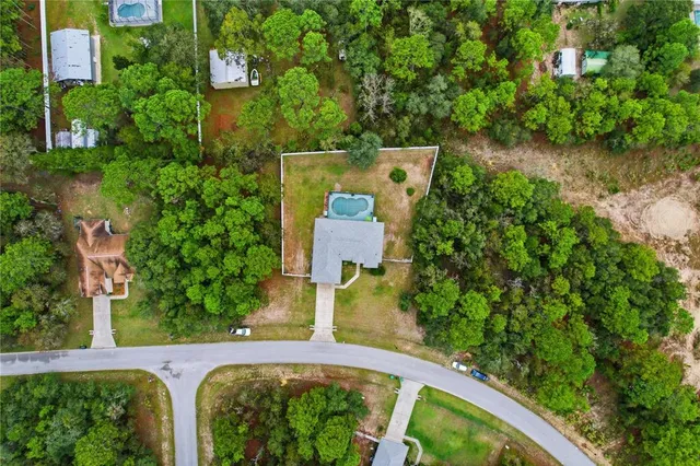 an aerial view of a house with swimming pool and garden space