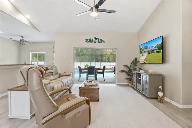 a living room with furniture a flat screen tv and a floor to ceiling window