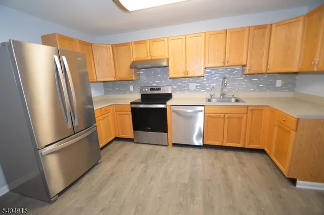a kitchen with stainless steel appliances granite countertop a refrigerator sink and microwave
