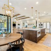 a kitchen with kitchen island a island a stove a table and chairs in it
