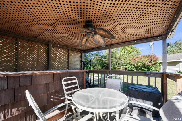 a view of a patio with a table chairs and a wooden fence