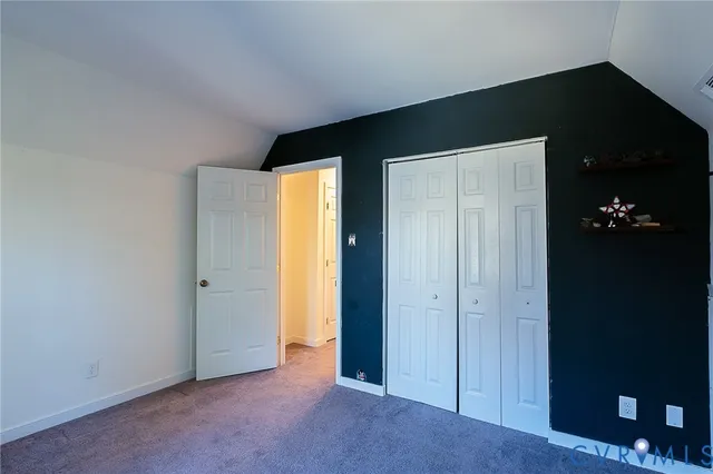 an empty room with a closet and wooden floor