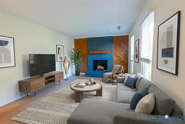 a living room with furniture a flat screen tv and a large window