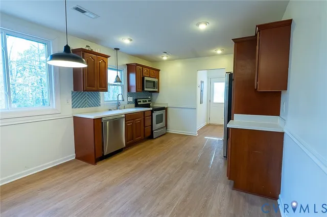 a kitchen with stainless steel appliances kitchen island granite countertop a stove a sink and a refrigerator