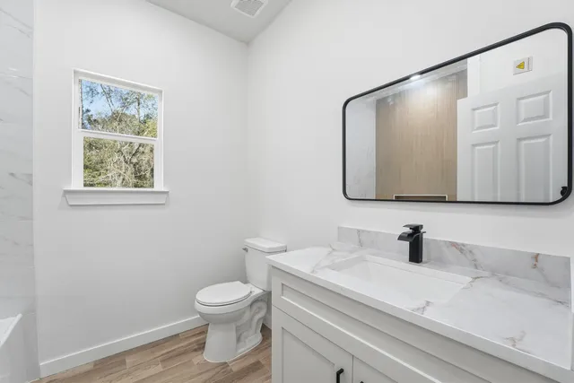 a bathroom with a toilet a sink and mirror
