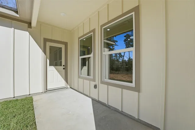 a view of a hallway with bathroom and front door