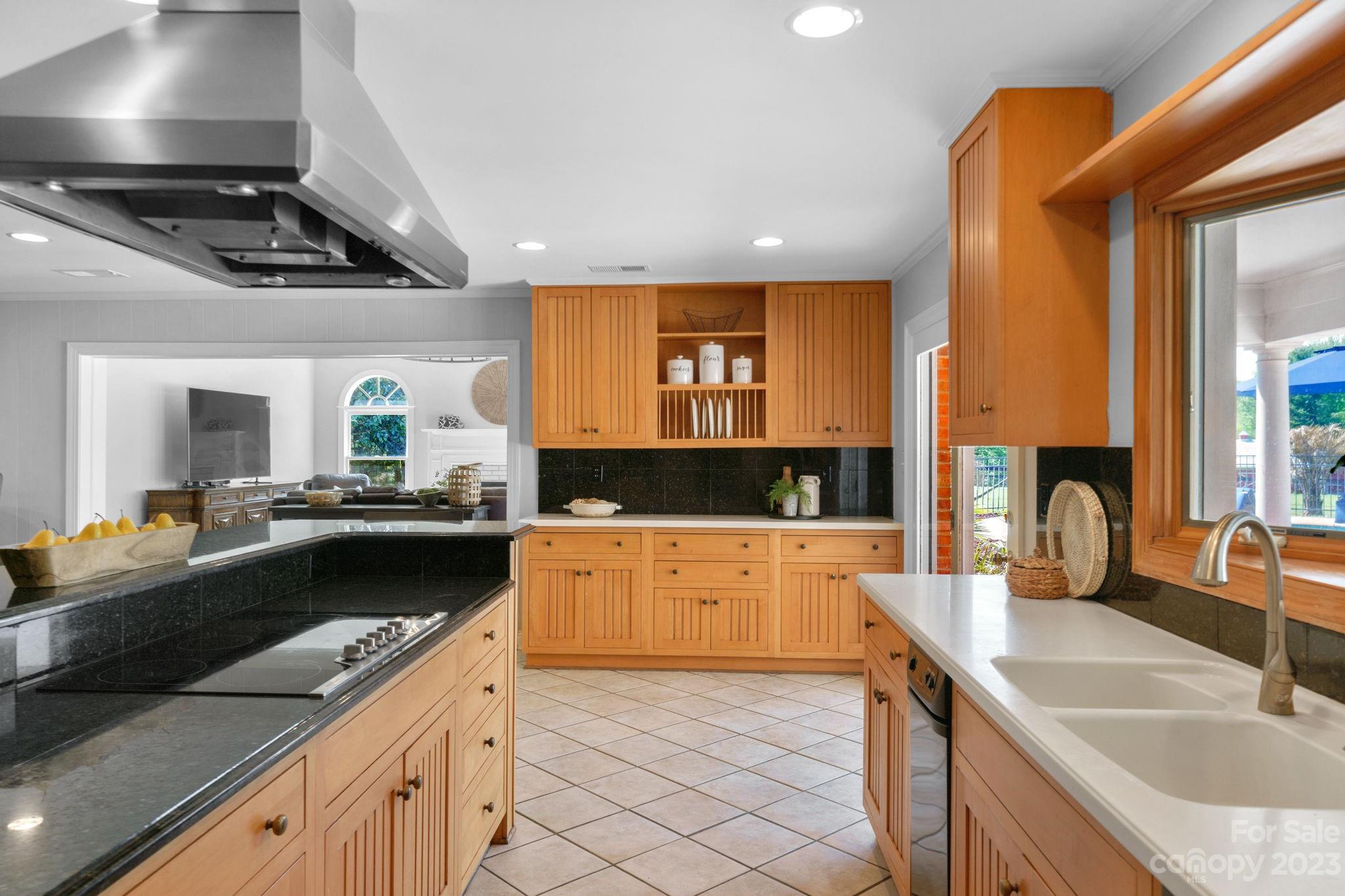 1916 Cox Road Matthews, NC 28104 - Photo 15 of 47 a kitchen with stainless steel appliances granite countertop a sink a stove and a wooden cabinets