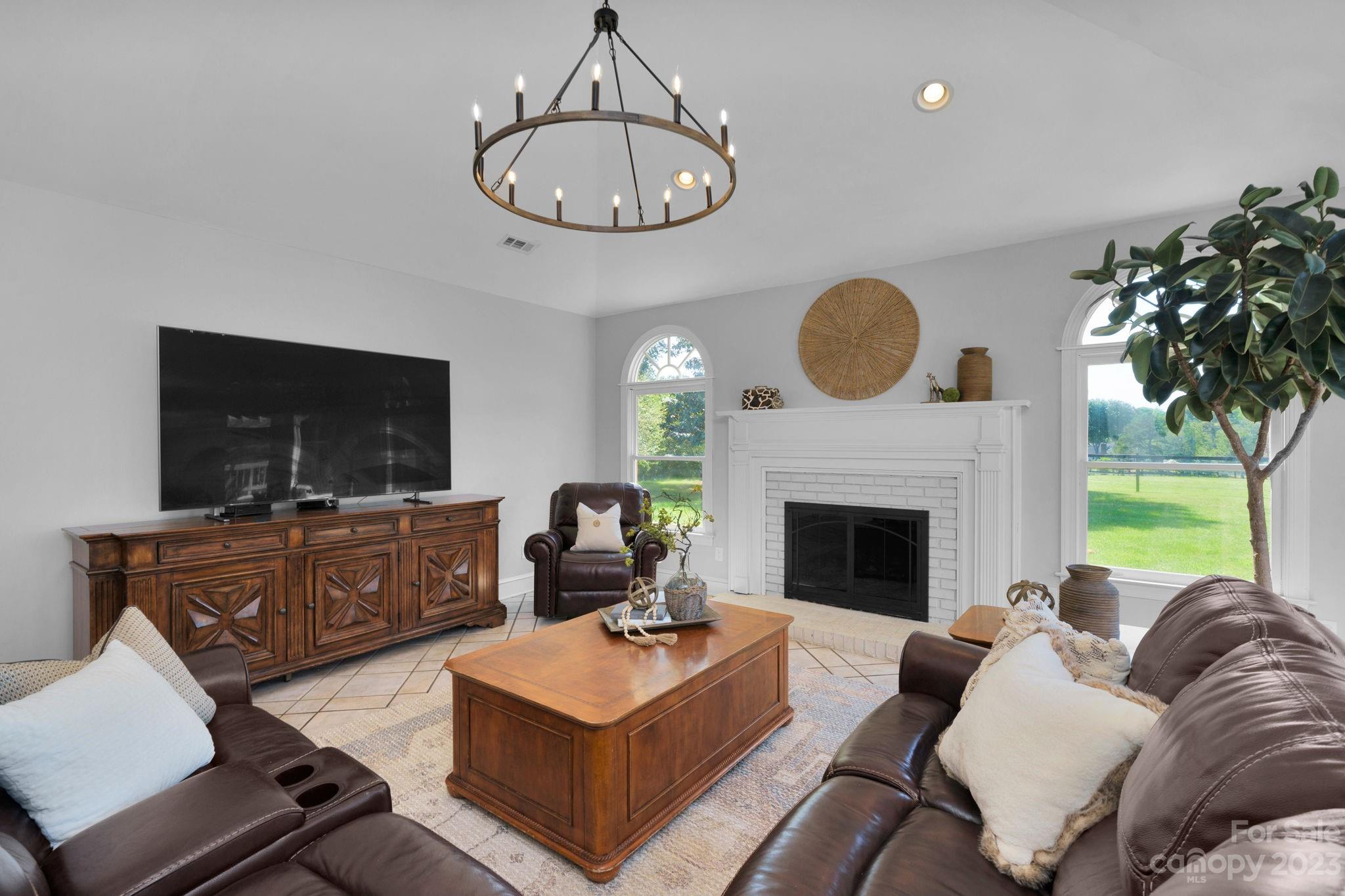 1916 Cox Road Matthews, NC 28104 - Photo 21 of 47 a living room with furniture a fireplace a flat screen tv and a large window
