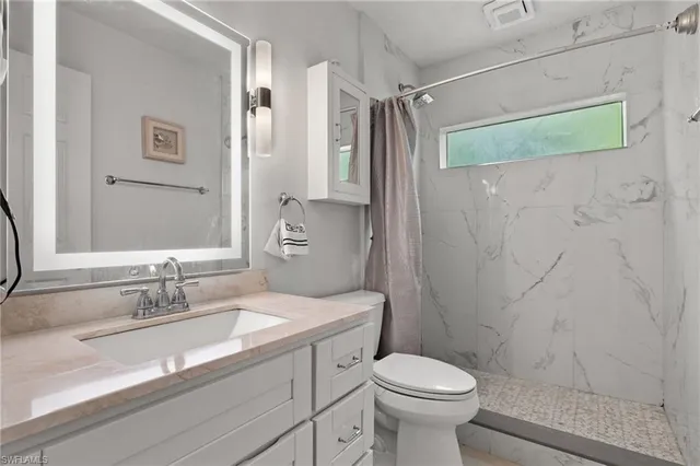 a bathroom with a sink toilet and shower