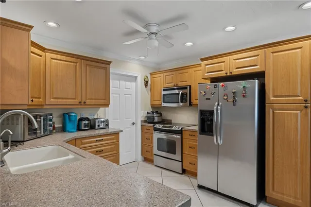 a kitchen with stainless steel appliances granite countertop a sink a stove a refrigerator a washer dryer and cabinets