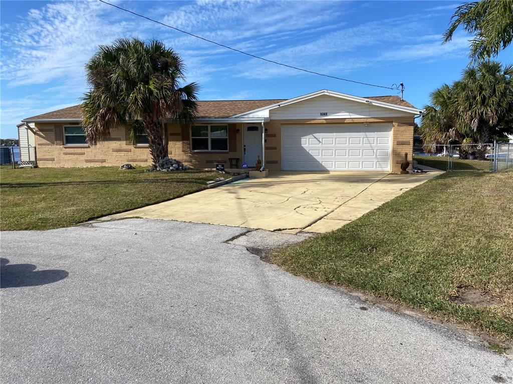 5343 Bluepoint Drive Port Richey, FL 34668 - Photo 1 of 28 a front view of a house with a yard and garage