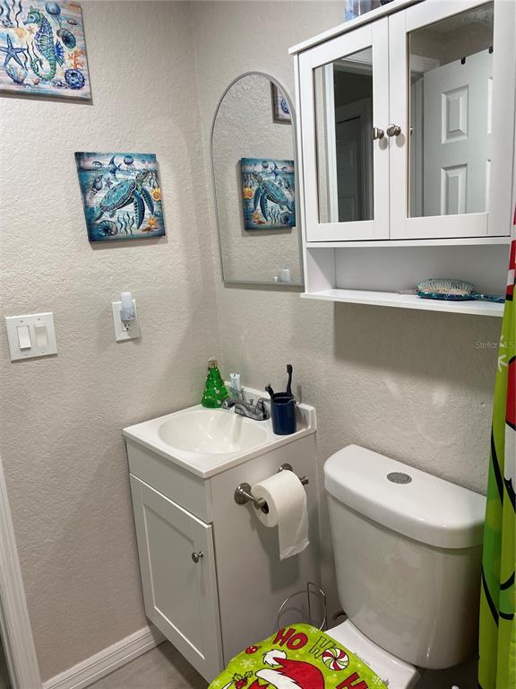 5343 Bluepoint Drive Port Richey, FL 34668 - Photo 27 of 28 a bathroom with a toilet a sink and mirror