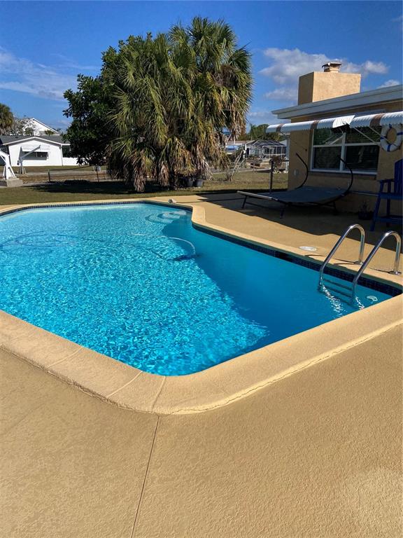 5343 Bluepoint Drive Port Richey, FL 34668 - Photo 4 of 28 a view of a swimming pool with an outdoor seating and a car parked