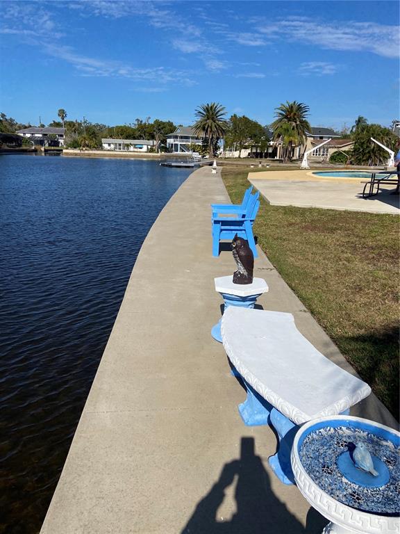 5343 Bluepoint Drive Port Richey, FL 34668 - Photo 6 of 28 a view of a lake with a table and chairs