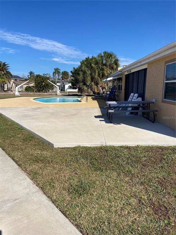 5343 Bluepoint Drive Port Richey, FL 34668 - Photo 10 of 28 a view of swimming pool with outdoor seating and house in the background