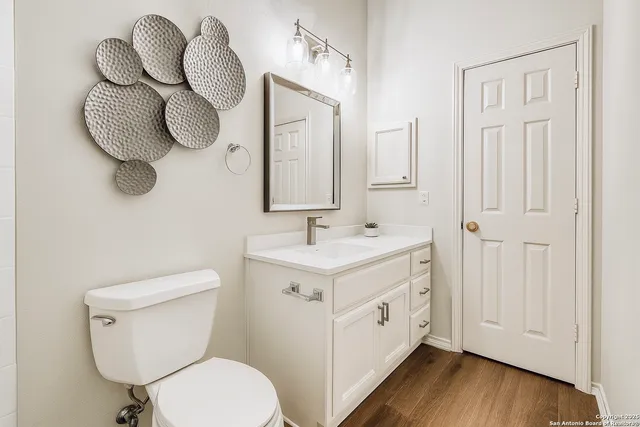 a bathroom with a sink mirror vanity and toilet