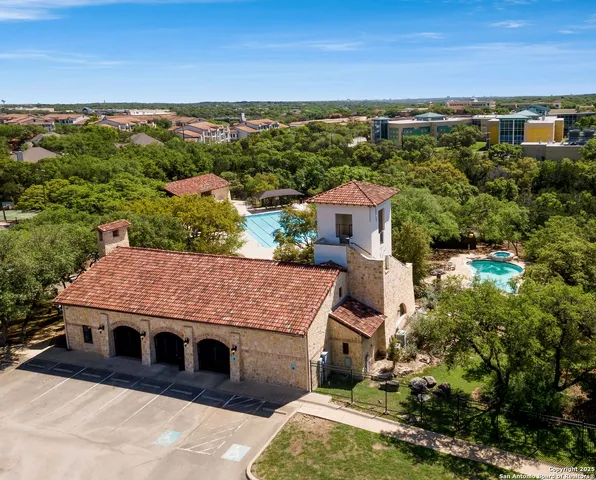 an aerial view of a house with a yard lake and mountain view in back