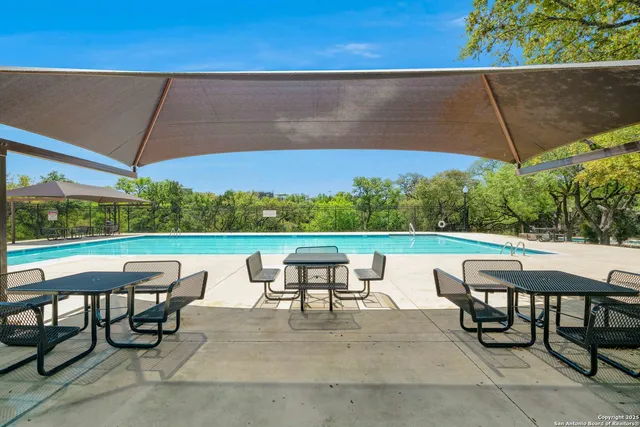 an outdoor sitting area with furniture and umbrella