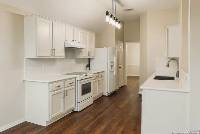 a kitchen with stainless steel appliances a white stove top oven and a sink