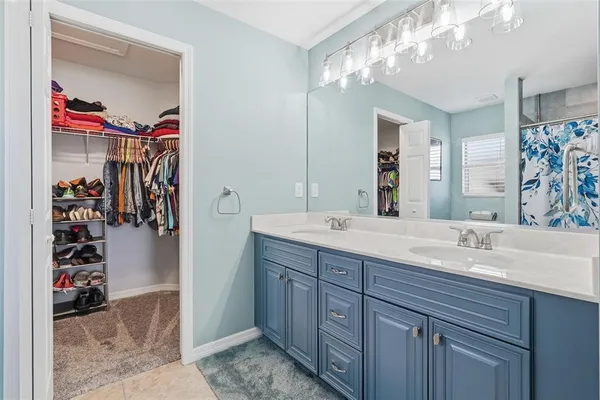 a bathroom with a granite countertop double vanity sink and a mirror
