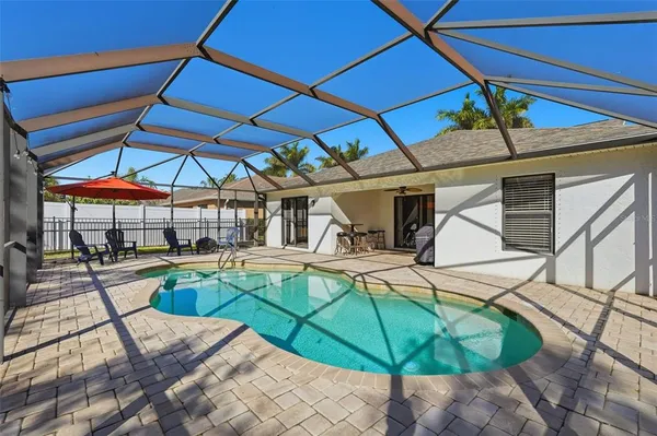 a view of a backyard with table and chairs under an umbrella