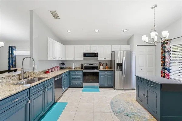 a large kitchen with stainless steel appliances kitchen island granite countertop a stove sink and refrigerator