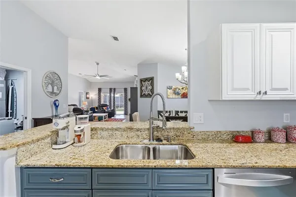 a kitchen with granite countertop a sink a stove and cabinets