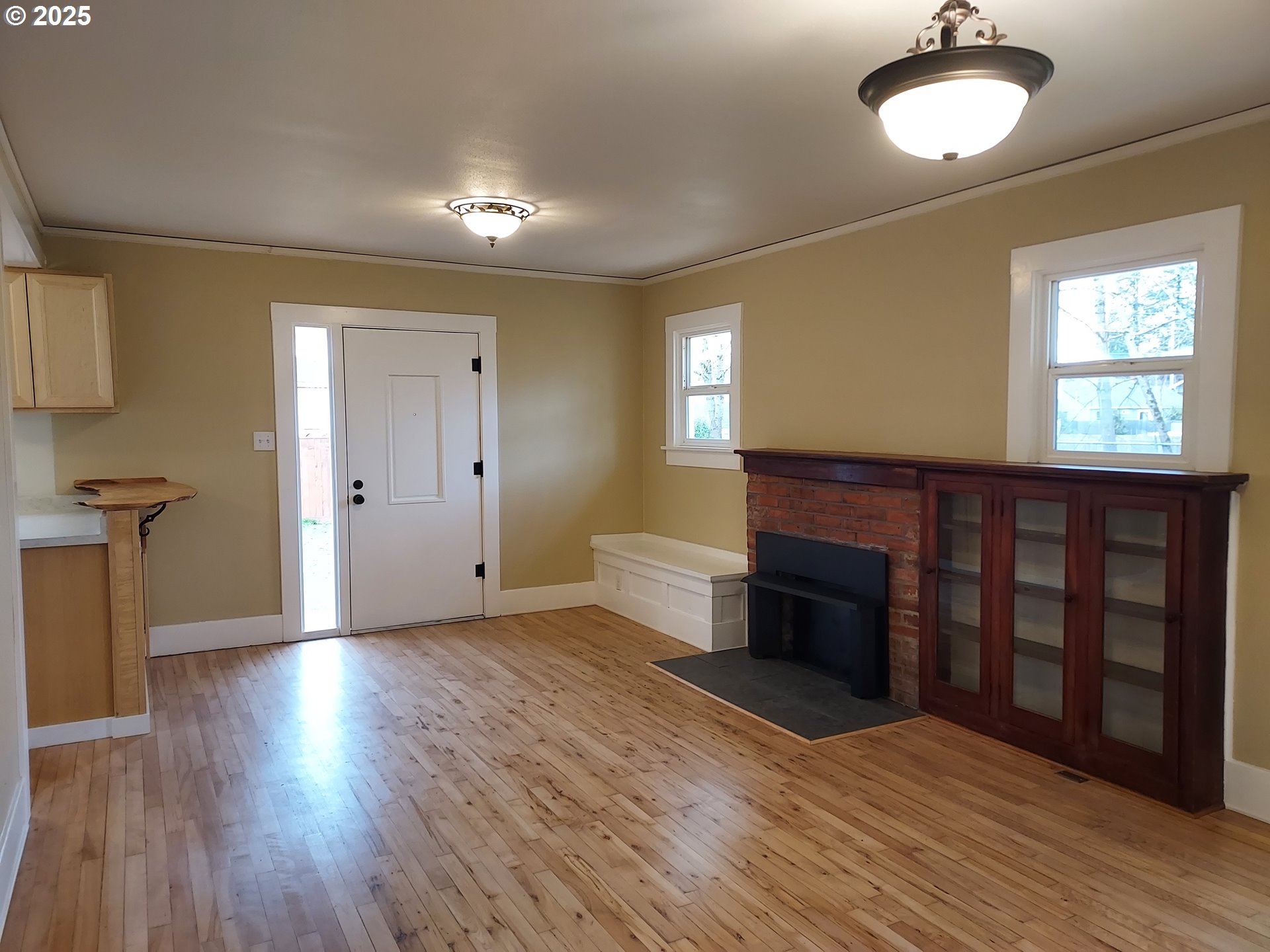 405 1/2 River Road Eugene, OR 97404 - Photo 3 of 18 an empty room with wooden floor fireplace and windows