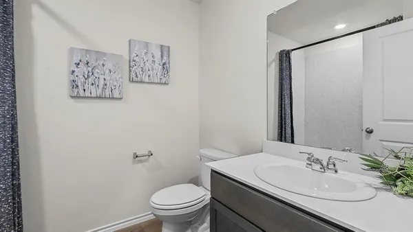 a bathroom with a granite countertop sink mirror vanity and toilet
