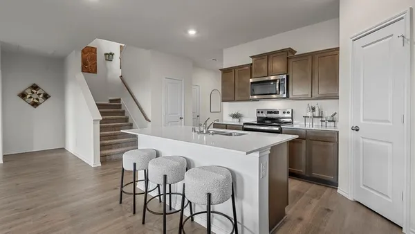 a kitchen with a sink cabinets and wooden floor
