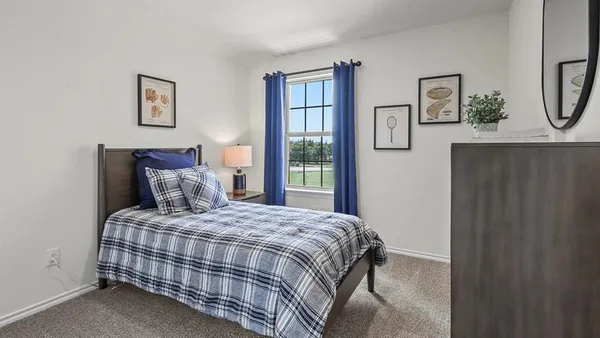 a bedroom with a bed and painting on the wall