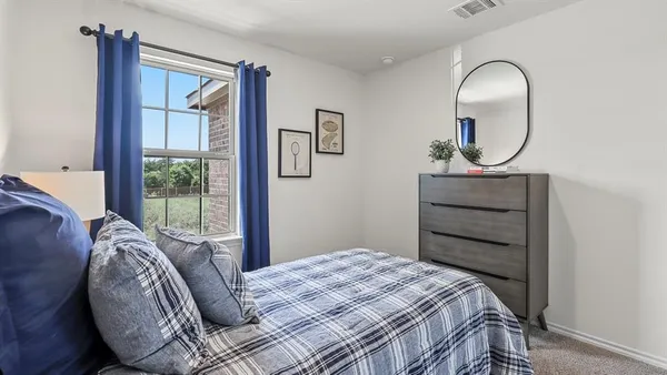 a bedroom with a bed and a mirror