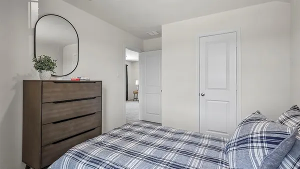 a bedroom with a bed and a mirror